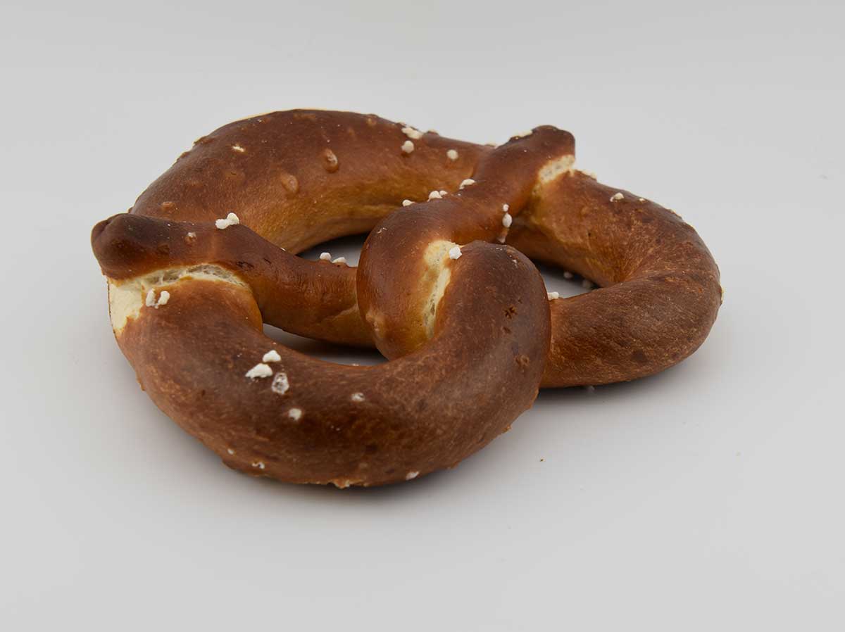 Een vers gebakken brezel, met grotere zoutkorrels erop.