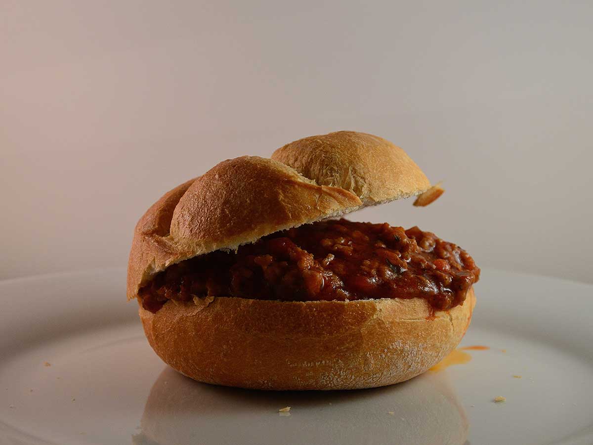 Een Sloppy Joe op een wit bordje.