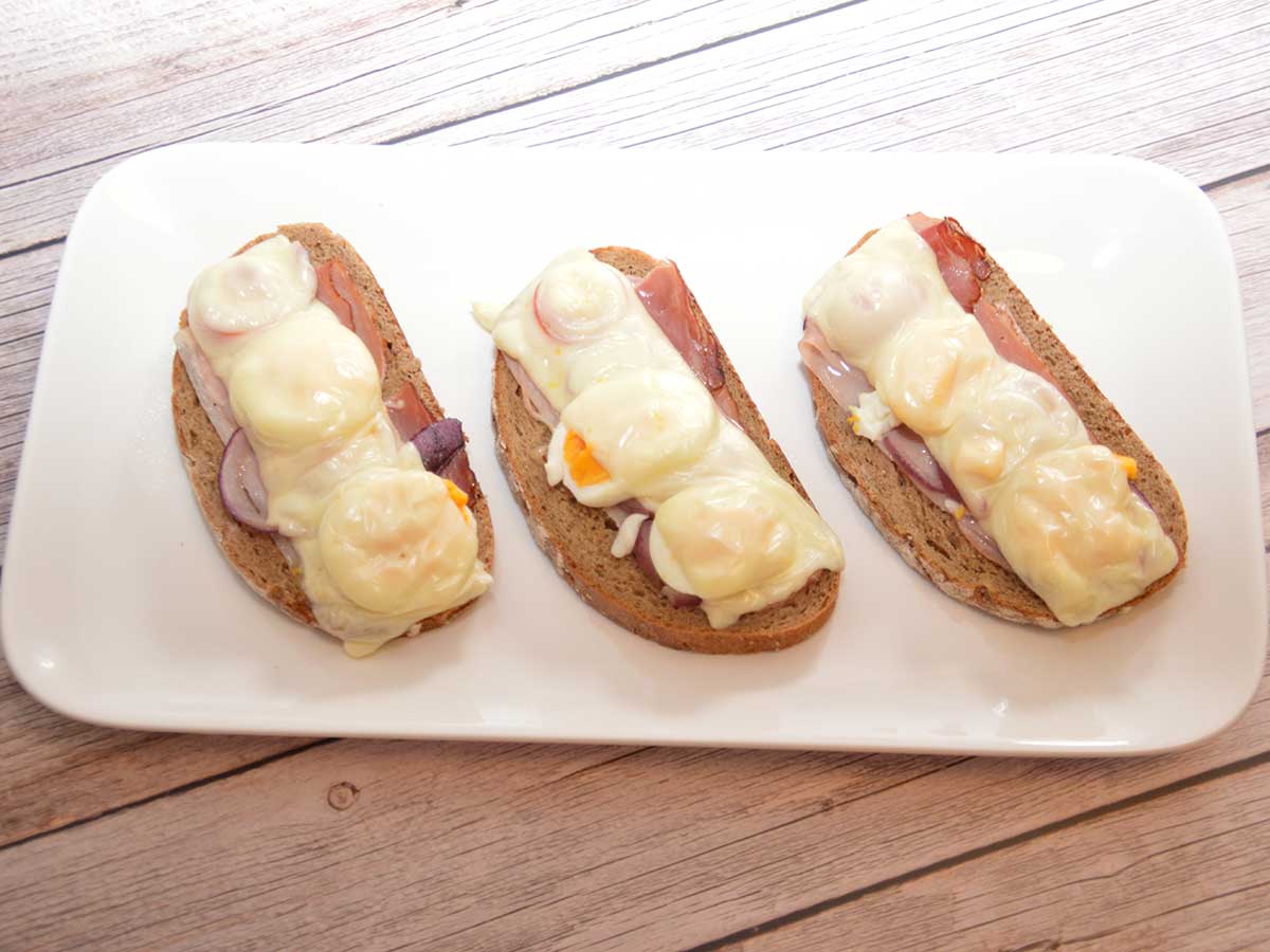 Een langwerpig bordje met 3 stukken Tiroler boerentoast.