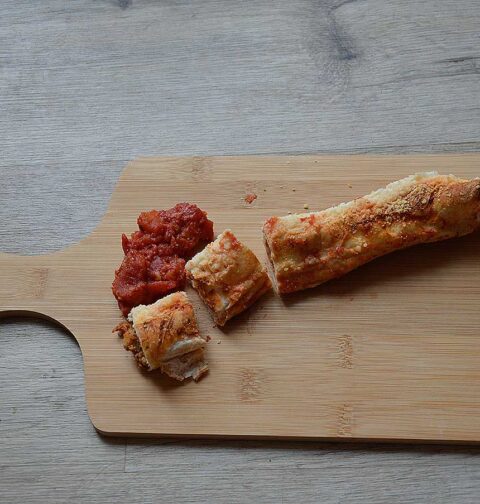 Een houten snijplank met daarop een wrap met gehakt uit de oven.